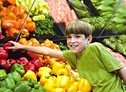 Boy reaching for a red pepper in super market. - Copyright – Stock Photo / Register Mark
